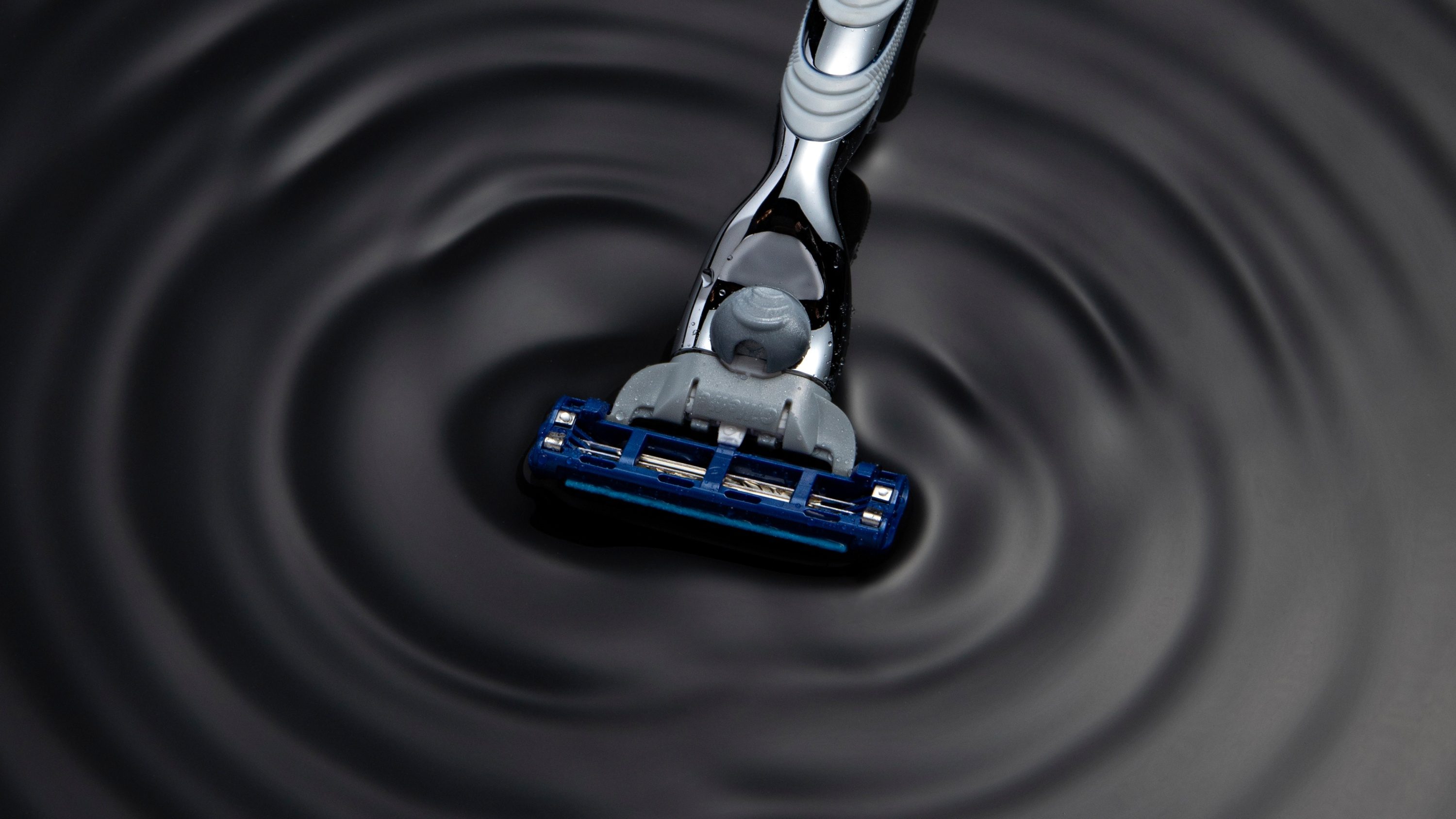 Aparelho Gillette mergulhando em ondas concêntricas sobre uma superfície escura