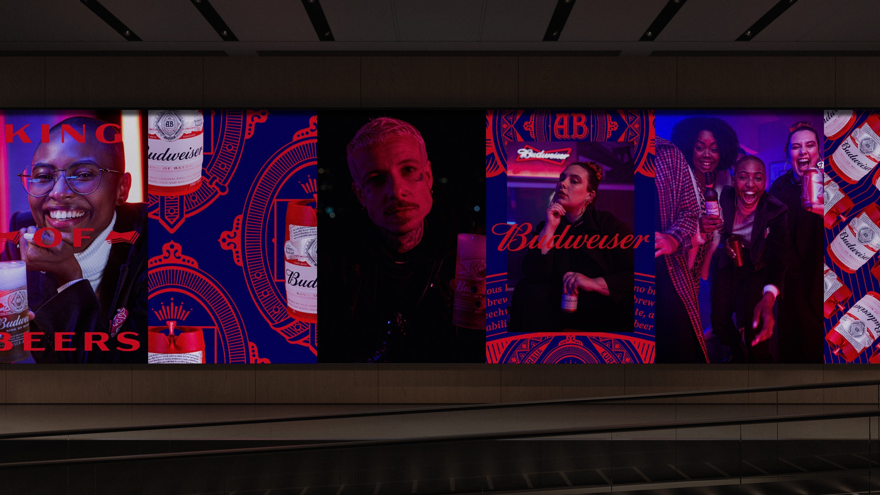 Painel de metrô com a campanha Big Bud: retratos, garrafas e padrões em vermelho e azul