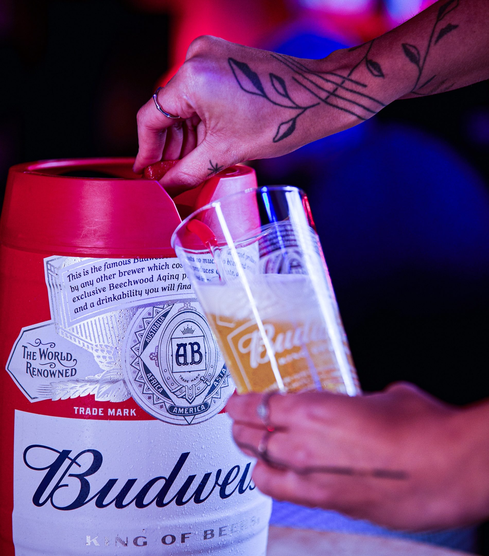 Mão servindo um copo de cerveja na torneira do barril de 5 litros da Budweiser
