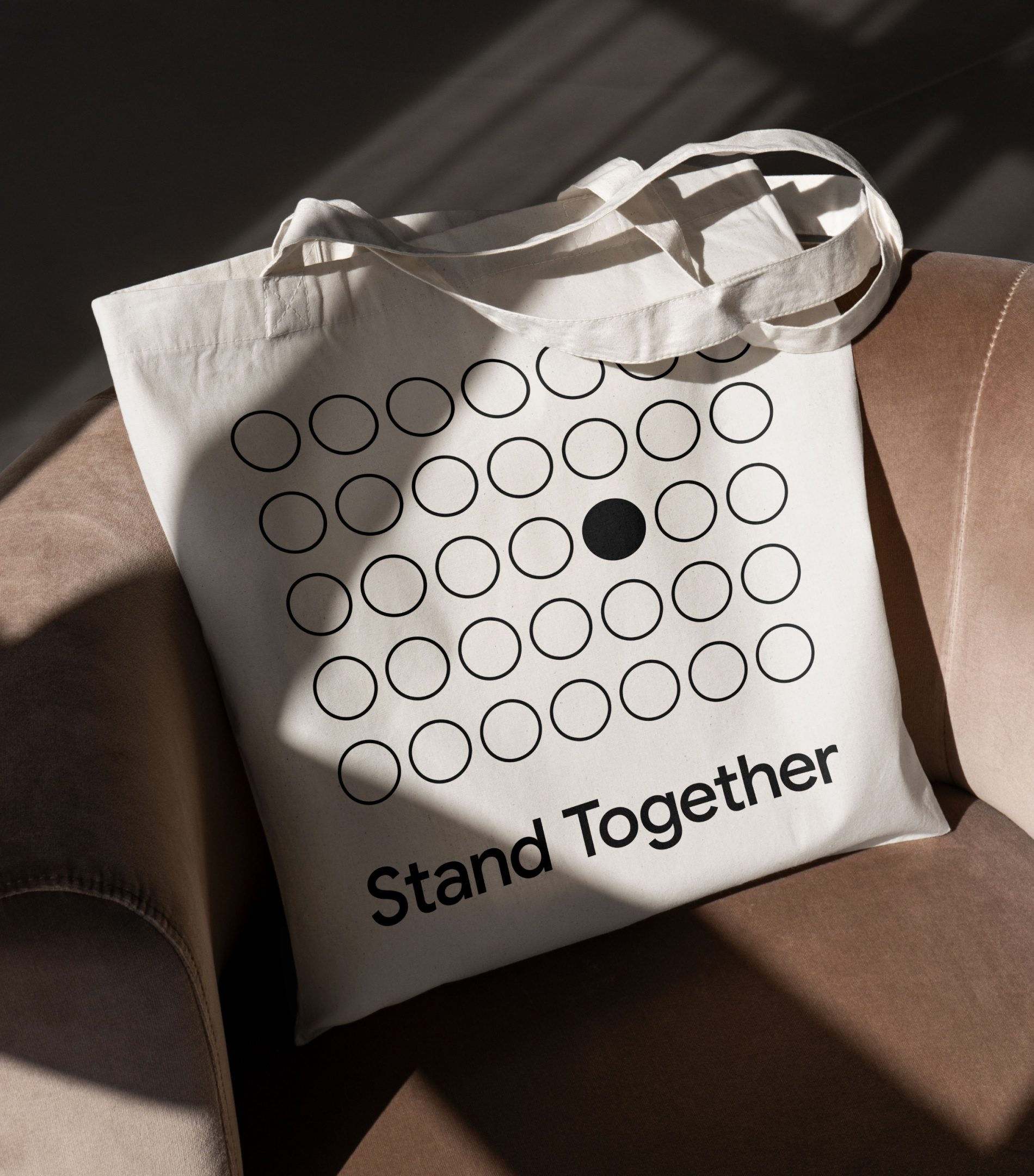 Ecobag numa poltrona com uma grade de círculos em contorno e um único círculo preto