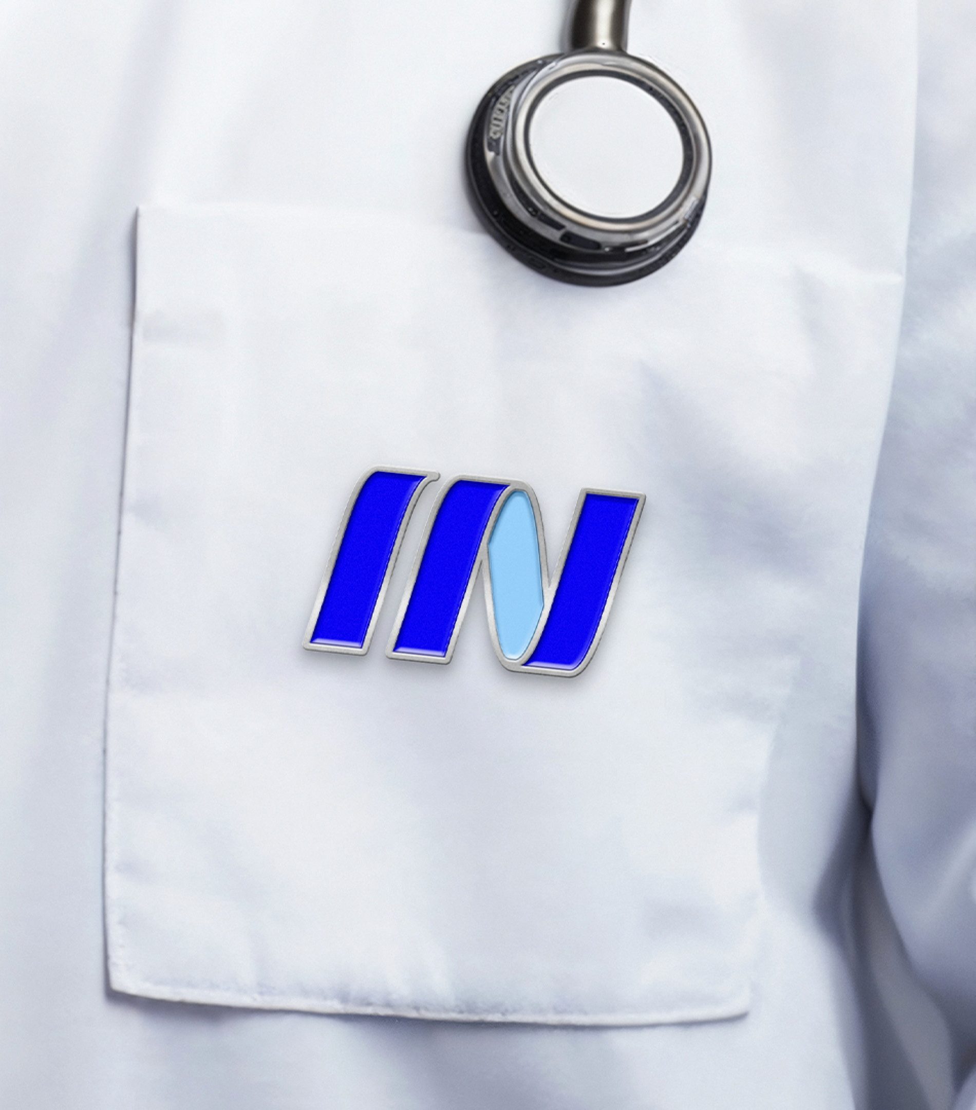 Broche com o símbolo In no bolso de um jaleco branco, ao lado do estetoscópio