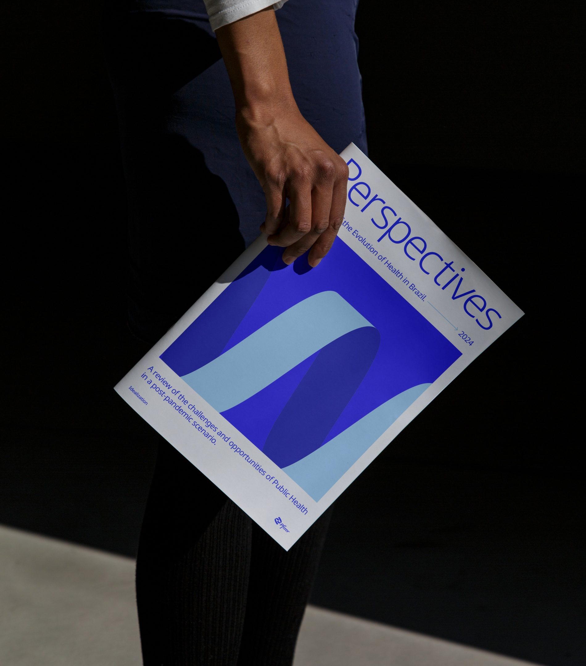 Mão segurando a revista Perspectives, com a fita em azul e azul claro na capa